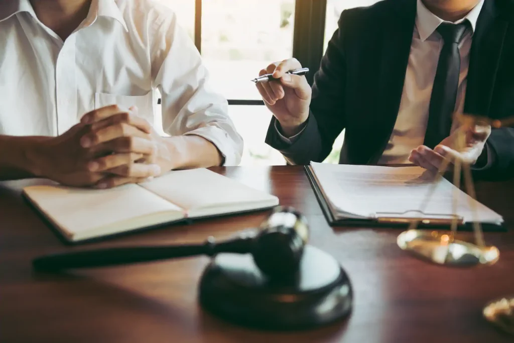 Abogado y cliente en consulta legal con mazo y balanza