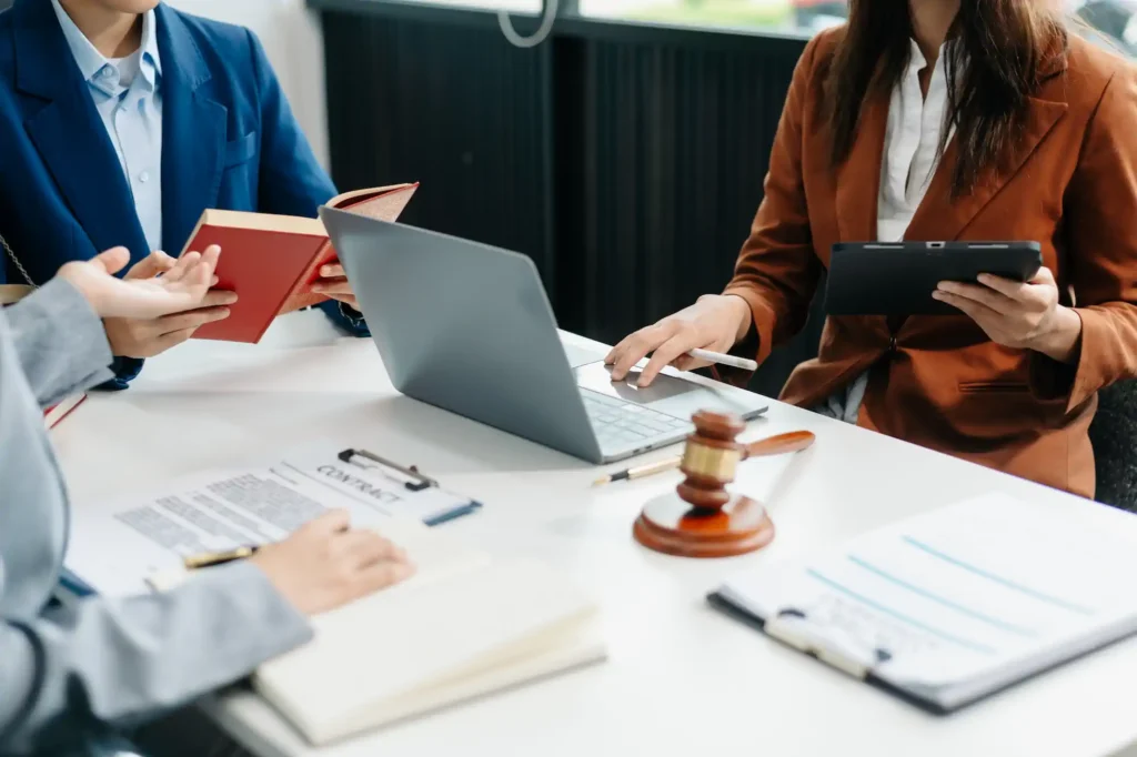 Abogados reunidos revisando contrato legal con mazo judicial