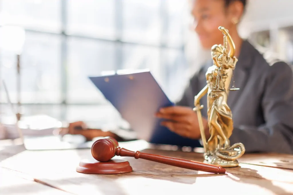 Abogada revisando documentos con mazo y estatua de la justicia