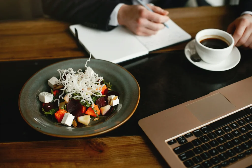 Ensalada colorida en escritorio con laptop y café