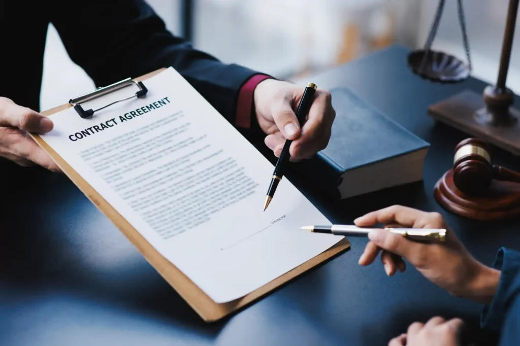 Abogado señalando contrato legal para firma del cliente