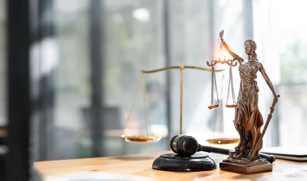 Estatua de la justicia, balanza y mazo en escritorio