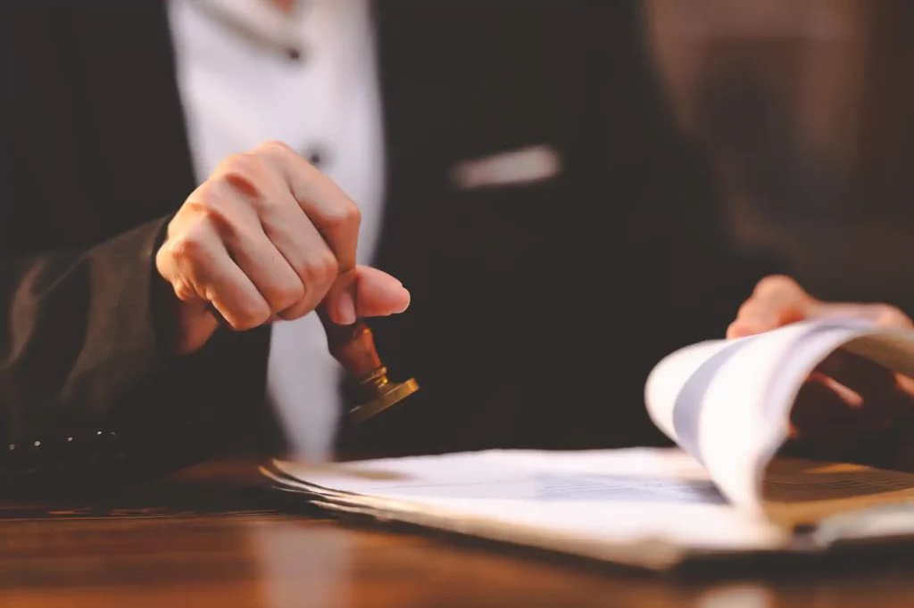 Persona de traje sellando documento oficial con sello de madera