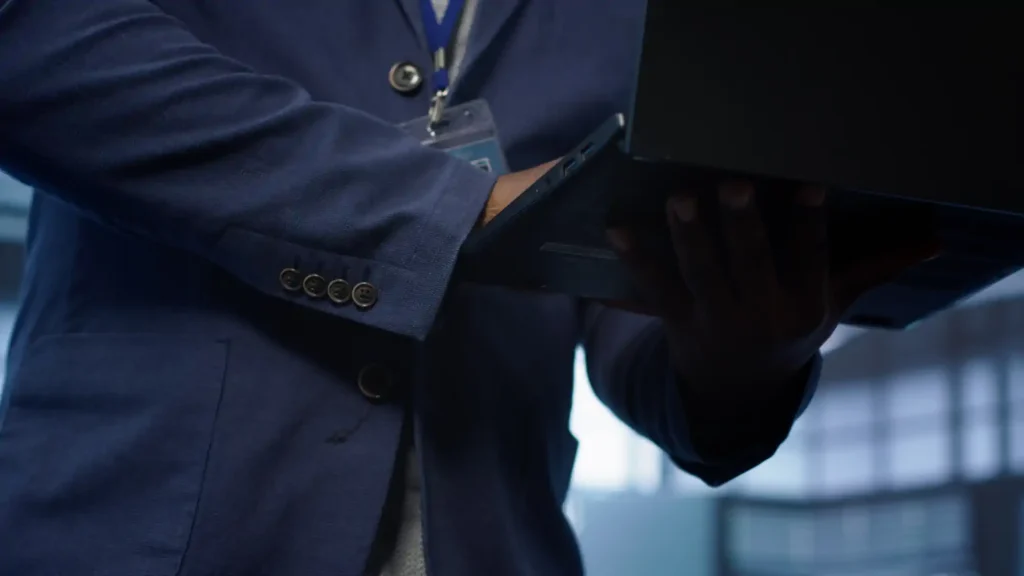 Profesional con traje azul usando laptop y gafete