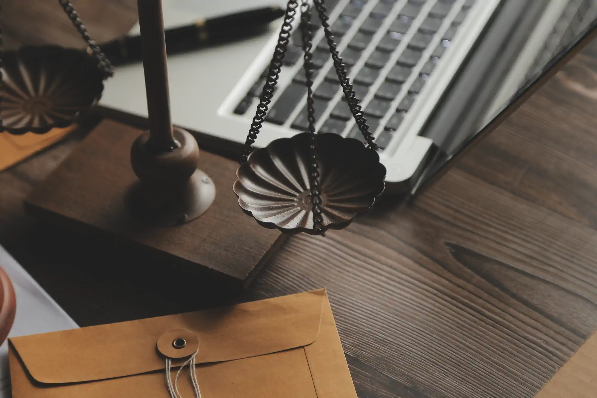 Balanza de la justicia en escritorio con laptop y sobre