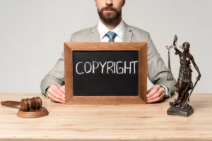 Abogado sostiene pizarrón con palabra COPYRIGHT en escritorio