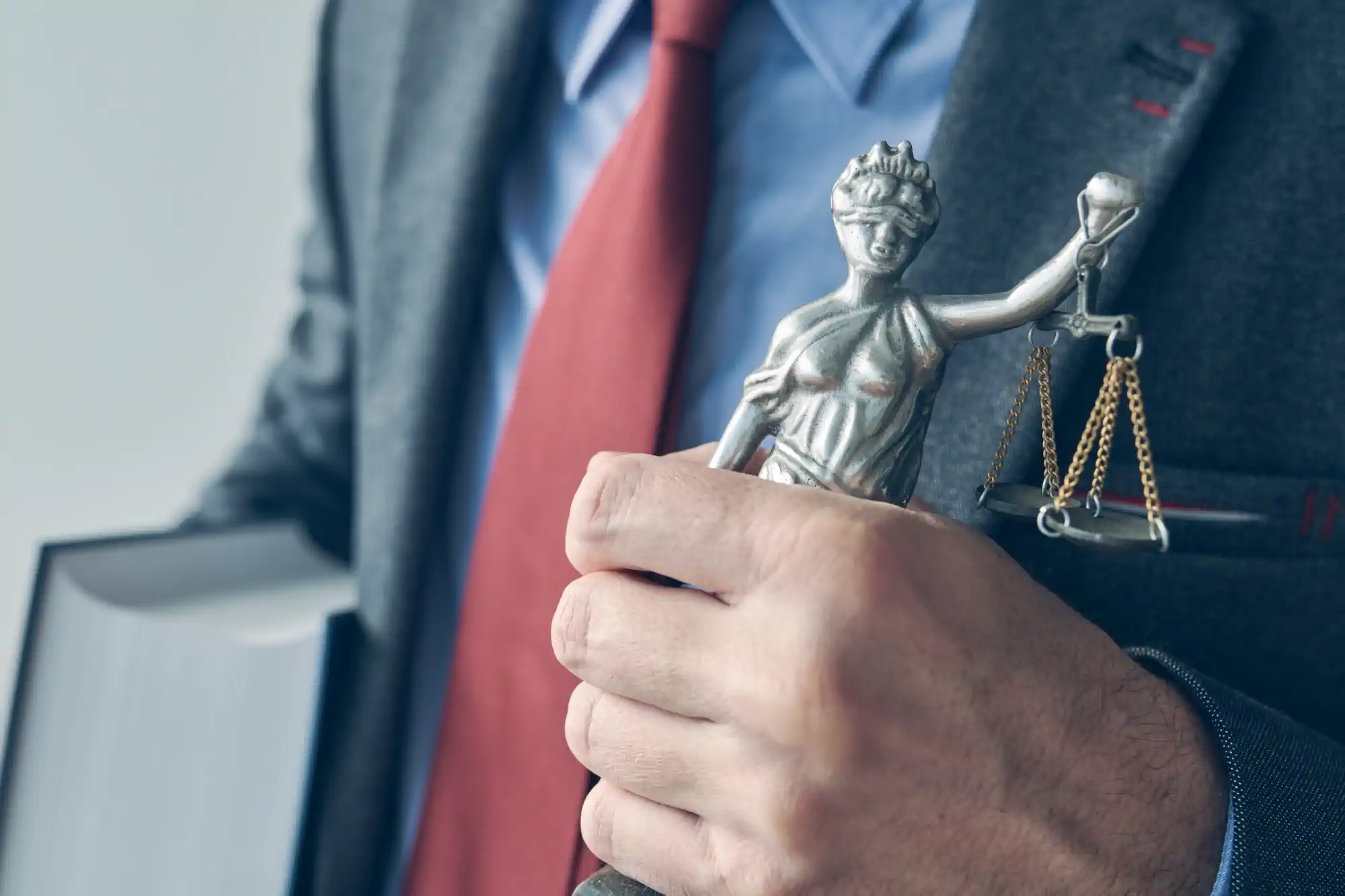 Abogado sosteniendo estatuilla de la diosa de la justicia